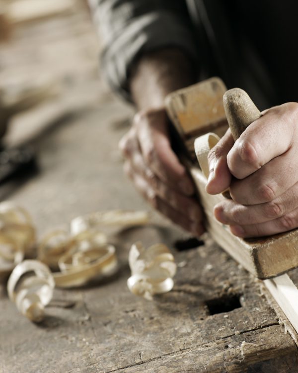 Hands of a carpenter planed wood, workplace